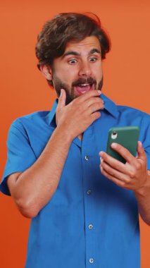 Mutlu, mutlu, neşeli adam akıllı telefon daktilo kullanıyor. 