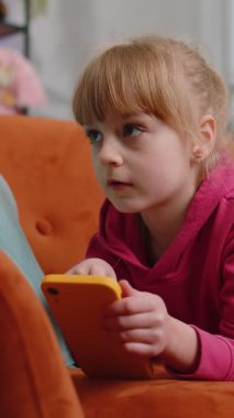 Akıllı telefonlu sosyal medya uygulamalarında mesajlar atan, rahatlama filmi izleyen, online alışveriş yapan, oyun oynayan çocuk kız. Genç bir bayan, evinde koltukta uzanmış cep telefonu kullanıyor. Dikey