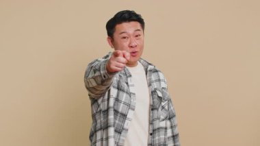 Hey sen! Mutlu Asyalı orta yaşlı adam heyecanlı bir şekilde gülümsüyor ve kamerayı ileri çeviriyor, şanslı oyun kazananını seçiyor, bu da sana müthiş bir terfi olduğunu gösteriyor. Çinli olgun adam bej arka planda izole edilmiş.