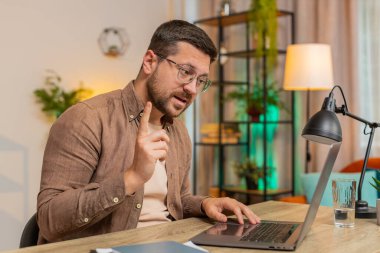 Ev ofisinin bilgisayarında çalışan mutlu iş adamı çalışanlarıyla online haberleşme videosu konuşması yapıyor, patron. Yönetici adam bilgisayarın webcam 'ine el sallayarak bakan servisleri destekler.