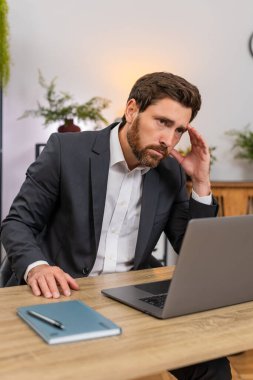 Merkez ofisteki orta yaşlı işadamı laptopta ödemeli e-posta okuyor ve kötü haberlerden sonra iç çekiyor. Masadaki serbest çalışan adam maaş kesintisini ve faturalar ve kira için sonraki adımları düşünmekten rahatsız oluyor..