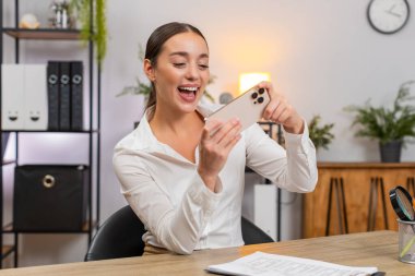 Ofisteki genç iş kadını akıllı telefondan oyun oynar mola verip gülümser. Masadaki serbest çalışan kız oyunu kapatıyor, dizüstü bilgisayarını açıyor, belgeleri geri getiriyor, görev tamamlanıyor ve çalışmaya devam ediyor..