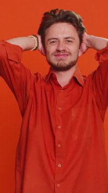 Üzgün, genç, Kafkasyalı bir adam umutsuzluk, yalnızlık, sinirsel çöküntü hissediyor. Piyango sonuçları, kötü şans, şanssız haberler karşısında şaşırıyor. Çekici adam turuncu arka planda izole edilmiş.