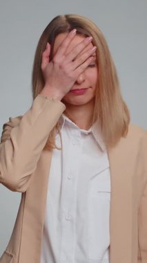 Avuç içi. Yazıklar olsun sana. Üzgün iş kadını surat hareketi yapıyor, sıkılıyor, hayal kırıklığına uğruyor, kötü haber. Resmi takım elbiseli kadın. Gri stüdyo arka planında izole edilmiş güzel bir kadın