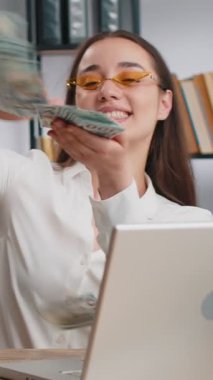 Neşeli, zengin, beyaz iş kadını dizüstü bilgisayarla çalışıyor ve kameraya para harcıyor. Daha fazla bahşiş, büyük kar getirir. Piyango alışverişi kazanır. Ofisteki serbest çalışan mutlu bayan.