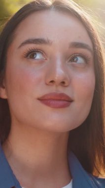 Mutlu genç kadın yüzünün yakın plan portresi gülen arkadaş canlısı, kameraya bakan mutlu yüz hayal kuran, dinlenen, rahatlatan, dışarıda iyi haberler veren. Şehir merkezinde güzel bir bayan güneşli bir sokakta