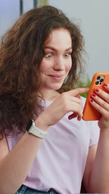 Mutlu genç bir kadın cep telefonu daktilosu kullanıyor ve 