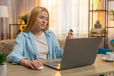 Kadın evden alışveriş yapıyor, eşyaları el arabasına taşıyor ve artan bir heyecanla dizüstü bilgisayarına kredi kartı verileri yazıyor. Kız sırıtıyor, düzgün alışverişi ve uygun dijital düzeni kutluyor..