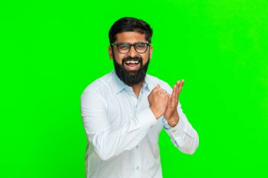 Hintli bir adam kararlı bir ifadeyle yumruğu avucunun içine atar. Hazırlığı ve harekete geçme dürtüsünü simgeler. Arap adam krom anahtar arka planda izole edilmiş. Güçlü bir kendinden emin hareket gösteriyor.