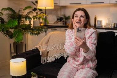 Akşamları evde çalışan orta yaşlı bir kadın akıllı telefonlara piyango vuruşu haberi veriyor. Gülümsüyor. Akşamları kanepede oturan beyaz kız iyi haberler okuyor zaferle el kaldırıyor..