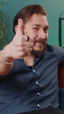 Gibi. Mutlu, heyecanlı Lübnanlı adam onaylayıcı bir şekilde kameraya bakıyor, olumlu bir işaret veriyor, iyi haber olumlu geri bildirim gibi. Genç Arap çocuk evdeki kanepede oturuyor.