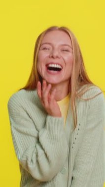 Komik anekdotları duyduktan sonra kahkahalarla gülen orta yaşlı mutlu bir kadın. Komik şakalara tepki veriyor, eğleniyor. Olumlu ifadeler. Sarı arka planda izole edilmiş genç bir kız.