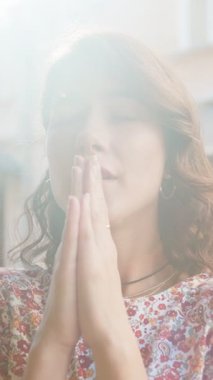 Kapalı gözlerle Tanrı 'ya dua eden üzgün bir kadının yakın plan portresi. Kutsama, umut yardımı, açık havada af diliyor. Şehir caddesinde el ele tutuşup şans dileyen bir kız. Din yaşam tarzları