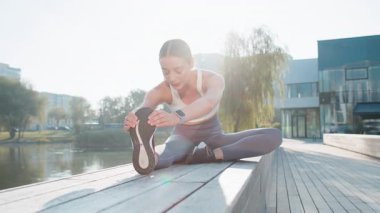 Koşudan önce sağlık, sağlık ve sağlık için şehir parkında bacak esneten bir kadın. Egzersiz, spor ve bayan sporcu dışarıda ya da doğada hareketlilik, esneklik ve güç için antrenman yapıyor..
