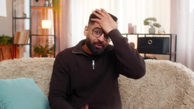 Evde oturan Hintli adam hatayı fark ettikten sonra kanepede oturur ve yüzünü hayal kırıklığıyla kapatır. Arap adam, duygusal hayal kırıklığı ve pişmanlık dolu tepkiler göstererek facepalm hareketleriyle tepki veriyor..