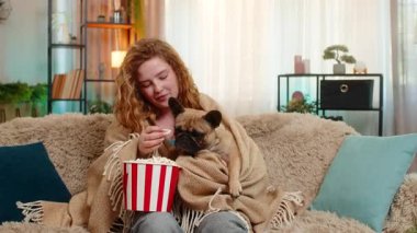 Genç, mutlu, beyaz saçlı kadın köpeğiyle televizyon izliyor. Kanepede oturuyor, ikisi de sıcak battaniyeye sarılmış. Kız elinde patlamış mısırla sükunet ve duygusal bağ kurmanın tadını çıkarıyor..