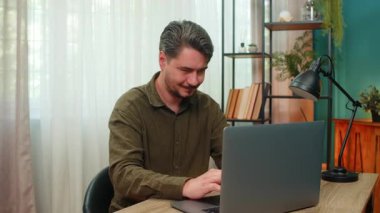 Evde çalışan orta yaşlı bir adam dizüstü bilgisayar raporunda büyük kazanç elde ettiği için el çırpıyor. Masadaki genç adam kontrat başarısını kutluyor. Gülümsüyor. İleride büyük bir kariyer artışı seziyor.