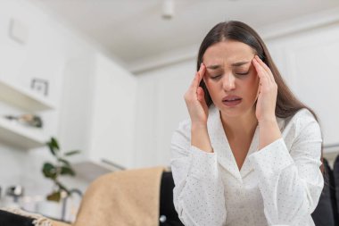 Evde başı ağrıyan genç bir kadın var. Şakaklarına masaj yapıyor. Yorgun hissediyor. Kanepede oturan beyaz kız gözlerini kapar migren krizi geçirir. Hüzünlü ruh hali..