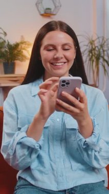 Gündelik kıyafetlerle gezen mutlu genç kadın akıllı telefon sosyal medya uygulamasında mesaj atıyor. Kanepede oturan ve evdeki oturma odasında cep telefonu kullanan beyaz bir kız. İnternette film izleyen kadın.