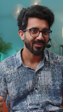 Kulaklık takan Hintli bir adamın POV 'u, serbest çalışan, çağrı merkezi ya da destek operatörü yardım hattı, müşteri ya da iş arkadaşı ile iletişim desteği için el sallıyor. Hindu çocuk sınıfında.