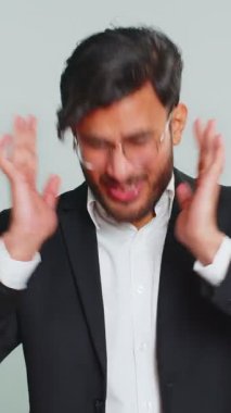 Duymak ve dinlemek istemiyorum. Sinirli, sinirli Hintli işadamı, kulaklarını tıkayarak hayır diyor, nahoş sesleri duymazdan gelerek tavsiyelerden kaçıyor. Gri arka plandaki Arap adam.