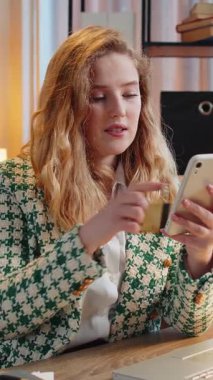 Kafkasyalı mutlu bir kadın banka kartı ve akıllı telefonu merkez ofisteki online alışveriş ödemeleri için kullanıyor. İş anlaşması. Gülümseyen kız cep telefonu E-bankacılık uygulama servisiyle serbest alım yapıyor..