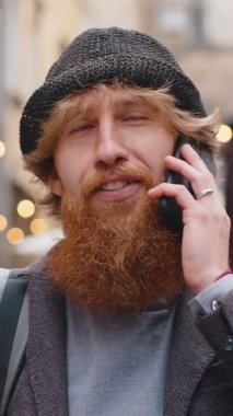 Mutlu sakallı adam uzaktan iletişim kurarak akıllı telefondan konuşuyor. Yakışıklı, yetişkin bir çocuk telefonda konuşuyor. Şehir caddesinde beklenmedik dedikodular dolaşıyor. Şehir yaşam tarzları açık havada