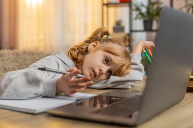 Genç kız evde dizüstü bilgisayarla ödev yaparken yorgun ve tembel hissediyor. Kafkas çocuk not defterine yazarak, çalışma zamanı boyunca sıkıntısını ve yorgunluğunu ifade ederek, mücadeleyi yansıtıyor.