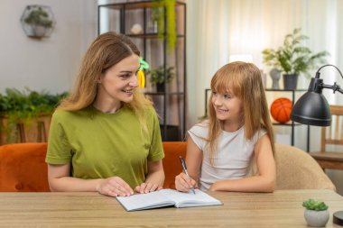 Evde anne ve kızı çizim yapıyor. Tic tac toe mermileri oynuyorlar. Defter ve kalemle skor tutuyorlar. Masa başındaki kadın ve kız çapraz hareket ediyor ve gülüyor. Dostça bir rövanş maçı. Rekor kırmayın.