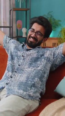 Yorgun Hintli adam rahat kanepeye uzanıp dinleniyor, gündüz uyukluyor. Kaygısız Hindu çocuğun portresi. Kafasının arkasında el ele tutuşuyor. Rahatlıyor, evinde kanepede uyuyakalıyor.