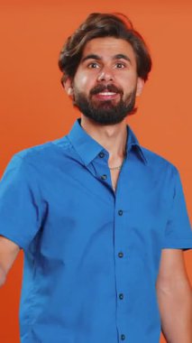 Sihirbaz cadı Orta Doğulu adam sihirli değnek ve sihirli değnekle el kol hareketi yapıyor dilekleri gerçekleştiriyor sihirbazlık büyüsü yapıyor, tatil indirimi yapıyor. Adam turuncu stüdyo geçmişinde izole edilmiş.