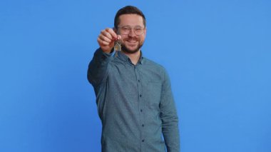 Gözlüklü beyaz bir genç emlakçı yeni ev dairesinin anahtarlarını kaldırıyor. Mülk alıp kiralıyor, ipotek kredisi veriyor, sigorta yaptırıyor. Mavi arkaplanda izole edilmiş adam