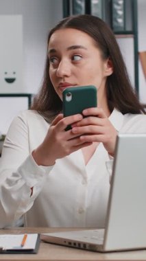 Akıllı telefonlu, heyecan verici mobil uygulamayla oynayan genç bir iş kadını ofis masasında oyun kazanmayı, nişancılık oyununu kutluyor. Profesyonel yönetici serbest çalışan bayan yeni uygulamanın keyfini çıkarın.