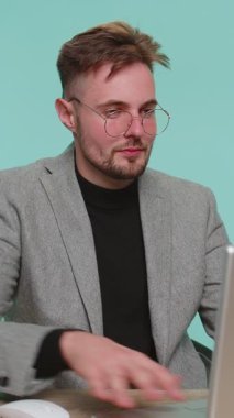 Aman Tanrım, vay canına. Ofis masasında oturan şaşkın iş adamı büyük gözlerle kameraya bakarken şaşırdı, ani zafer, oyun kazanma, piyango kazanma, mavi arka planda iyi haberler.