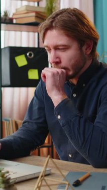 Sıkıcı uykulu işadamı dizüstü bilgisayarla çalışıyor esneme hareketleri yapıyor, el kamerasıyla ev ofis masasında uyuyor. Yorgun, Kafkasyalı, serbest çalışan, işkolik bir adam. İstihdam, meslek, işsiz.