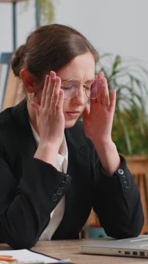 Kafkasyalı hasta iş kadınının baş ağrısı, gerginlik ve ofis masasında migren stresinden muzdarip olması. Dizüstü bilgisayarla çalışan serbest çalışan bir borsacı kadın. Fazla çalışma