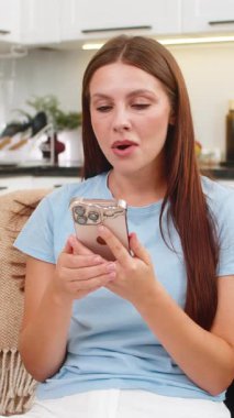 Evdeki genç kadın akıllı telefonda dil uygulaması kullanıyor kelimeleri ve cümleleri tekrarlıyor ve puanın arttığını görüyor. Kanepedeki beyaz kız iyi reyting alıyor. İzleme serisi artış, neşe ve gururla gelişimi kutluyor.