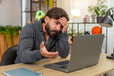 Evdeki Hintli adam dizüstü bilgisayar programının çökme hatası ekranında donma facepalm bozukluğunu gördü. Masadaki Arap adam uygulamayı yeniden başlatıyor. Virüs ve veri kaybı için endişelenen antivirüsü kontrol ediyor. Güncelleme sonrası sinirli ruh hali.