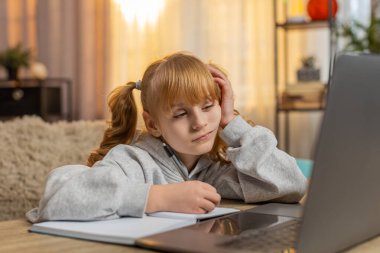 Genç kız evde dizüstü bilgisayarla ödev yaparken yorgun ve tembel hissediyor. Kafkas çocuk not defterine yazarak, çalışma zamanı boyunca sıkıntısını ve yorgunluğunu ifade ederek, mücadeleyi yansıtıyor.