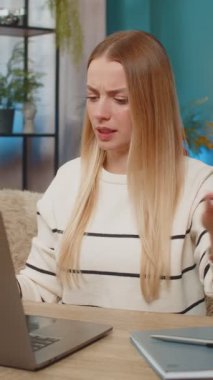 Masadaki beyaz kadın dizüstü bilgisayar, virüs hatası, kayıp veri, ekran, tıkırtı tuşları, endişeli, umutsuz, düzeltilmeye ihtiyacı var. Kafası karışmış, hayal kırıklığına uğramış, başını tutup yardım isteyen bir kız.