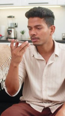 Akıllı telefondaki Hintli adam cevap vermeden önce mikrofon seviyesini yavaşça kontrol ediyor. Kanepedeki Arap adam ses konuşmalarıyla stres noktalarına sesleniyor ve kaydı bitiriyor.