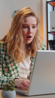 Aman Tanrım, vay canına. Dizüstü bilgisayarda çalışan mutlu beyaz iş kadını ani zafer, maç kazanma, piyango hedefi başarısı ve iyi haberle şok oldu. Yurt içi ofis masasında serbest çalışan kız..