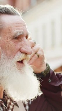 Mutlu sakallı yaşlı adam, kablosuz kulaklık takıyor, dışarıda dans eden en enerjik disko rock n roll müziğini dinliyor. Şehir caddesinde yürüyen yaşlı büyükbabanın portresi
