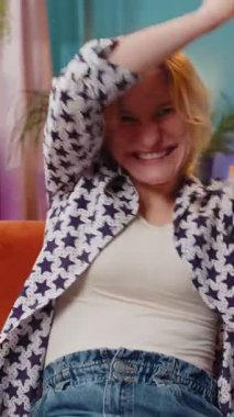 Başarılı beyaz kadın elinde dolar banknotları tutan bir hayranla sınıftaki kanepede oturuyor. Mutlu heyecanlı kız çevrimiçi kumarhane oyunu kazanıyor tatil planlama evde bütçe hesaplama.