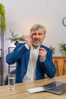 Merkez ofisteki orta yaşlı işadamı yorgunluk masajını hissediyor baş ağrısı haplarını yutarak suyla yıkıyor. Masadaki serbest çalışan adam görevine devam etmeye hazırlanıyor. Acıyı azaltıyor..
