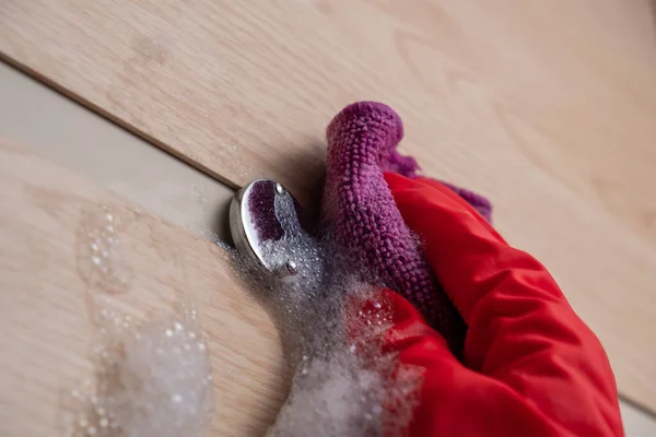 Kırmızı eldivenli bir el kapıyı yıkar..