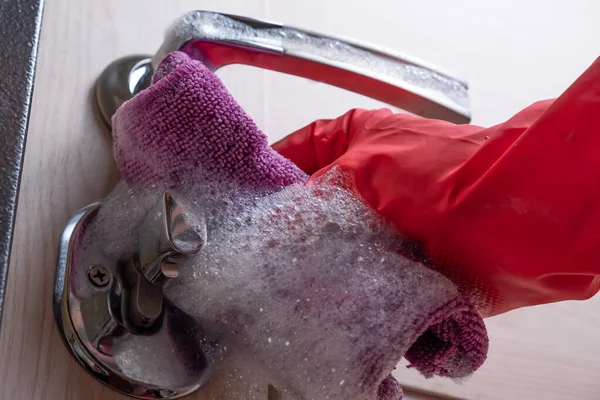 Kırmızı eldivenli bir el kapıyı yıkar..