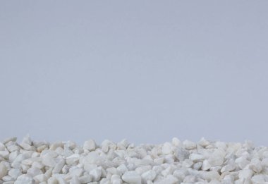 Açık gri arkaplanda küçük beyaz taşlar 