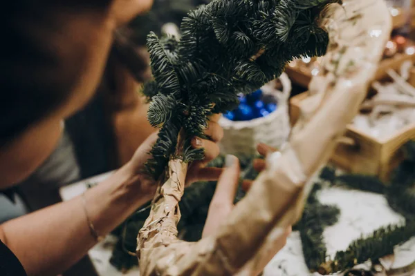 Woman making christmas wreath. A master class on creating a Christmas wreath from a natural spruce with your own hands. A Christmas wreath made with your own hands.