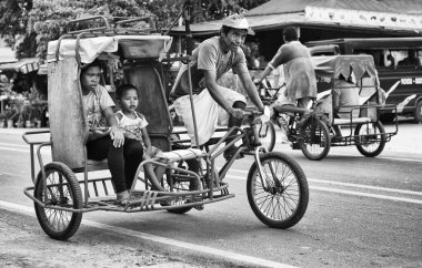 Bohol, Philippines - Feb 3: traditional and typical transport in the street of Bohol, Philippines,Feb 3, 2014. Tricycle motor taxi, Philippines inexpensive transport service. Black and white photo clipart